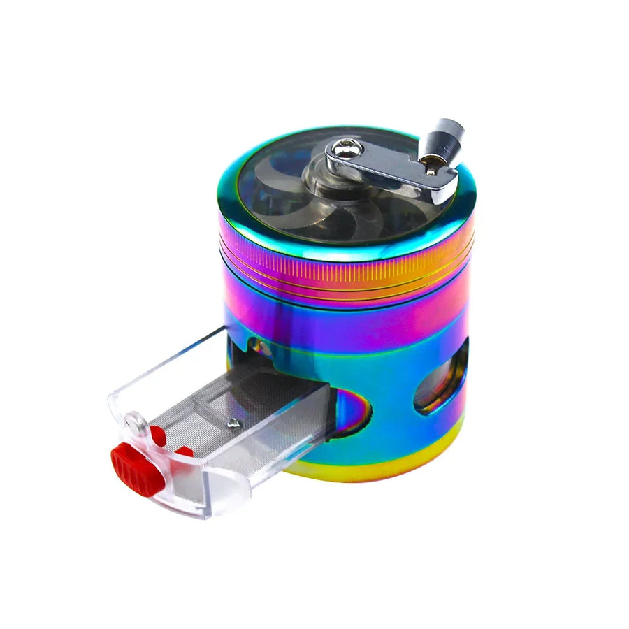 A portable cylindrical metal grinder with an iridescent rainbow finish, featuring a clear plastic hopper drawer with a red release button and a silver metal handle on top, shown on a white background.