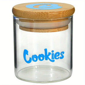Clear glass jar with wooden lid and blue 'Cookies' text on a white background